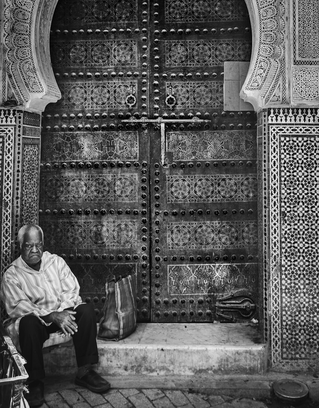 elderly man sitting at door